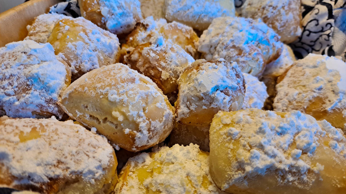 Fresh beignets, dusted with powdered sugar, begging to be eaten.