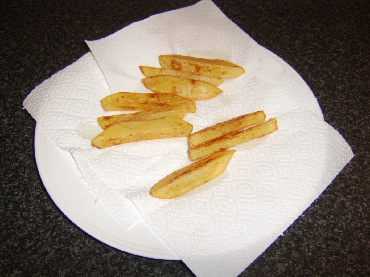 After being fried for a second time, the chips are drained on fresh kitchen paper