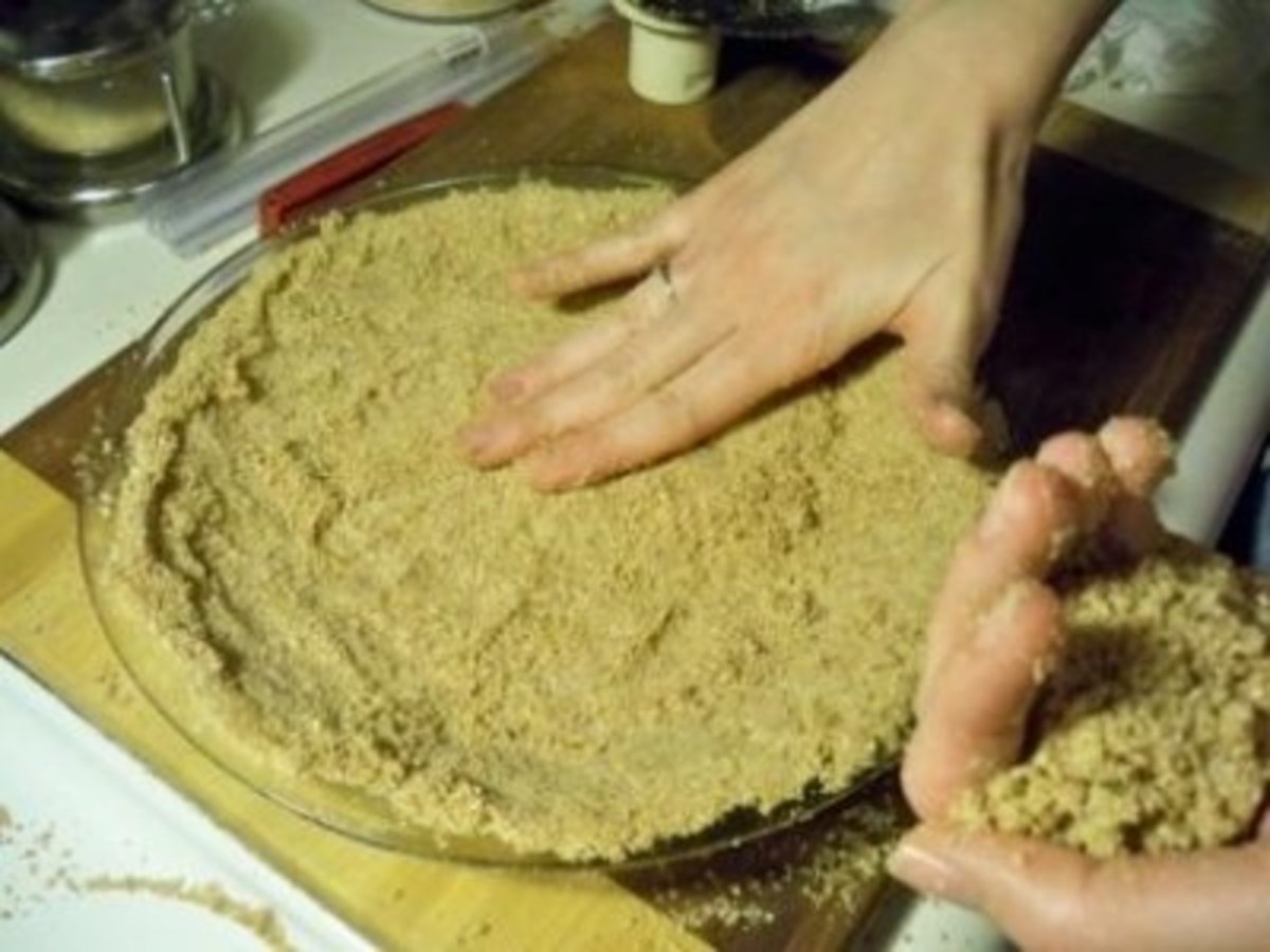pressing the matzo meal crust into the pie pan