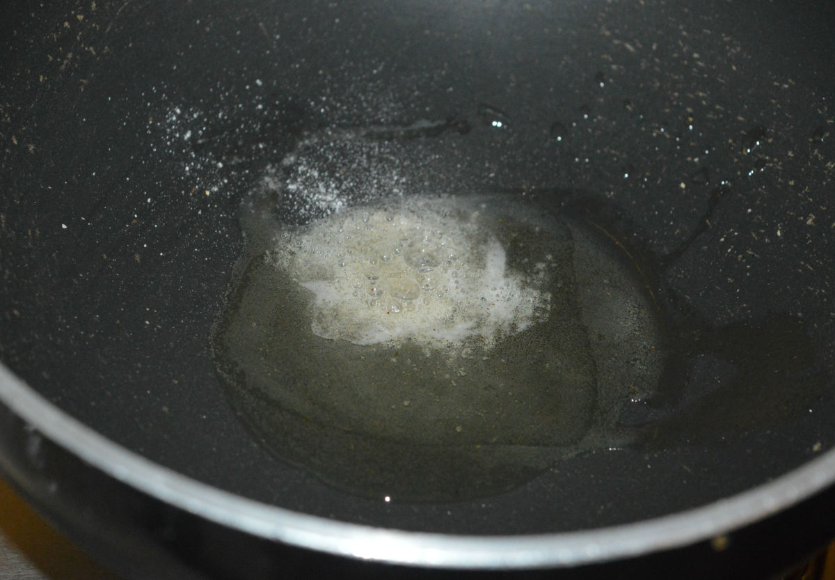 Step two: In a deep-bottomed pan, heat the oil. Add hing powder. Saute for 5 seconds on low heat.