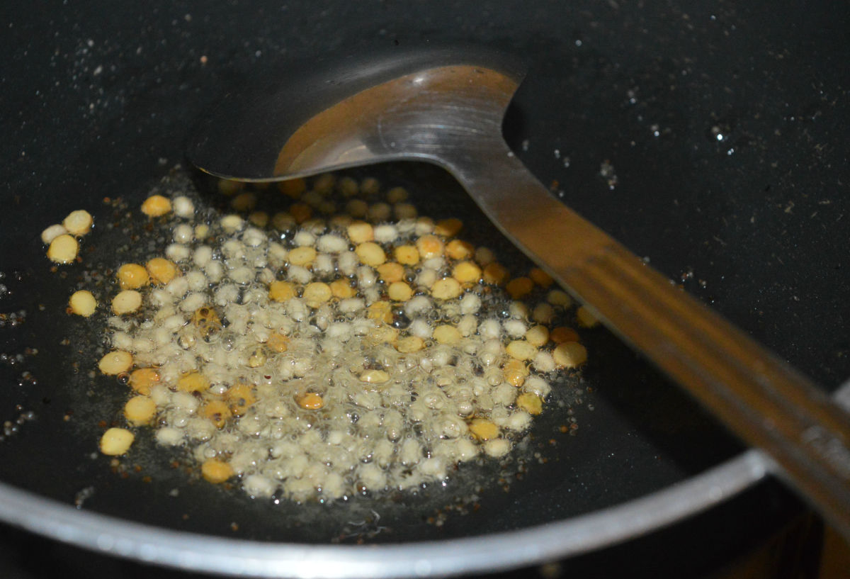 Throw in split Bengal gram and urad dal. Continue to saute until the dals become golden brown.