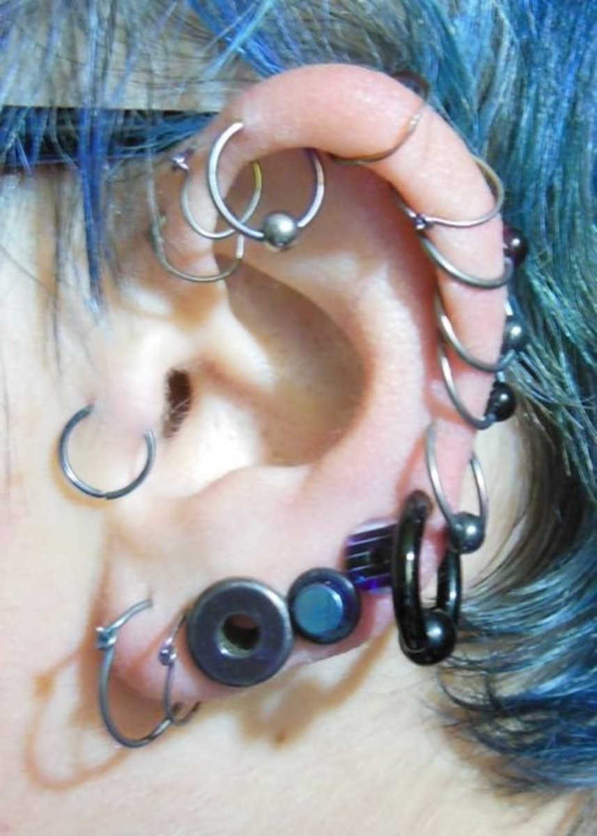 An ear full of tunnel and plug piercings: 2g tunnel, 4g titanium plug, 2g plastic plug
