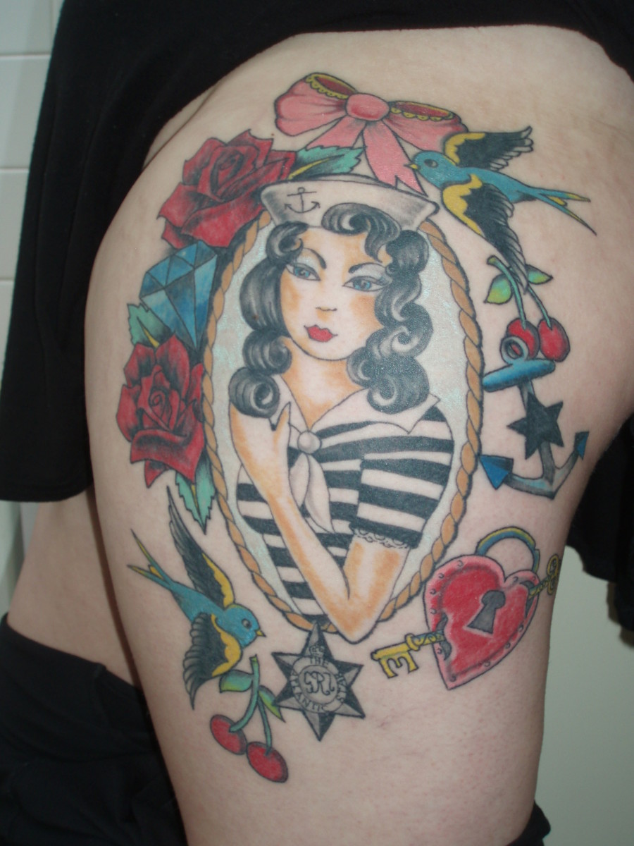 A sailor-inspired pinup girl tattoo with other imagery.