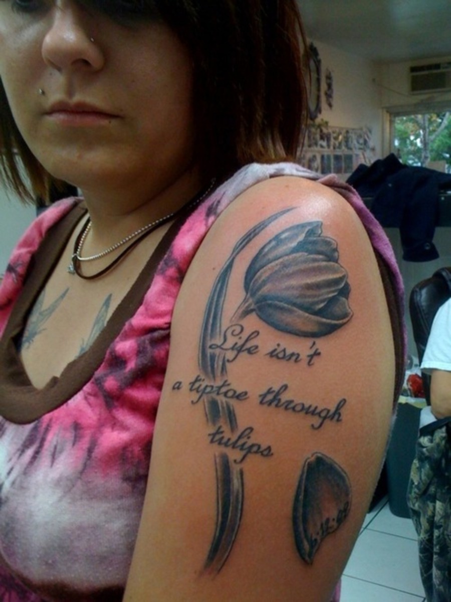 an arm tattoo that says, "life isn't a tiptoe through tulips"