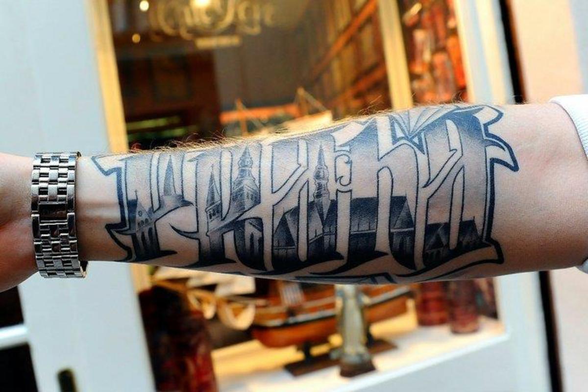This tattoo design incorporates text and images seamlessly.