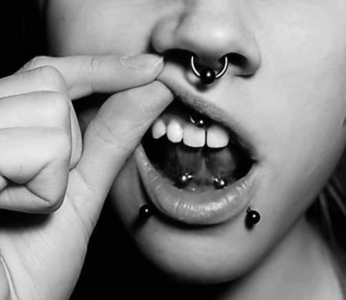 Count how many different types of piercings this person has just from nose to jaw.