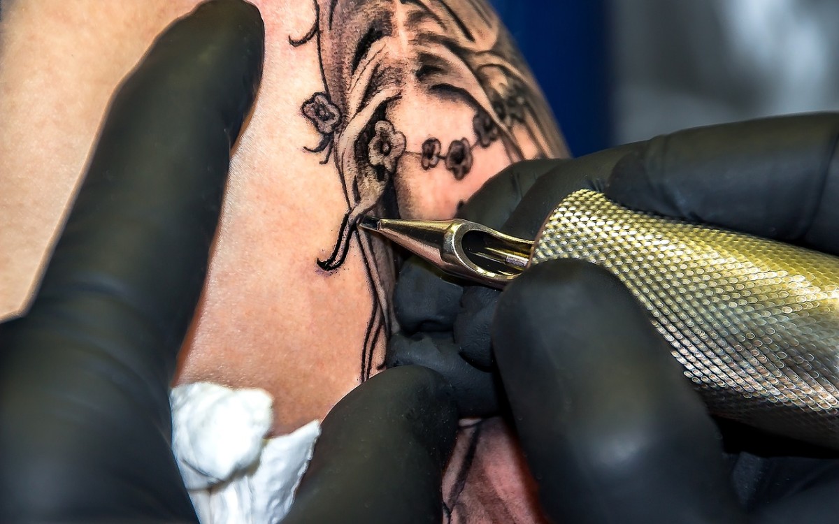A tattoo artist creating a tattoo.