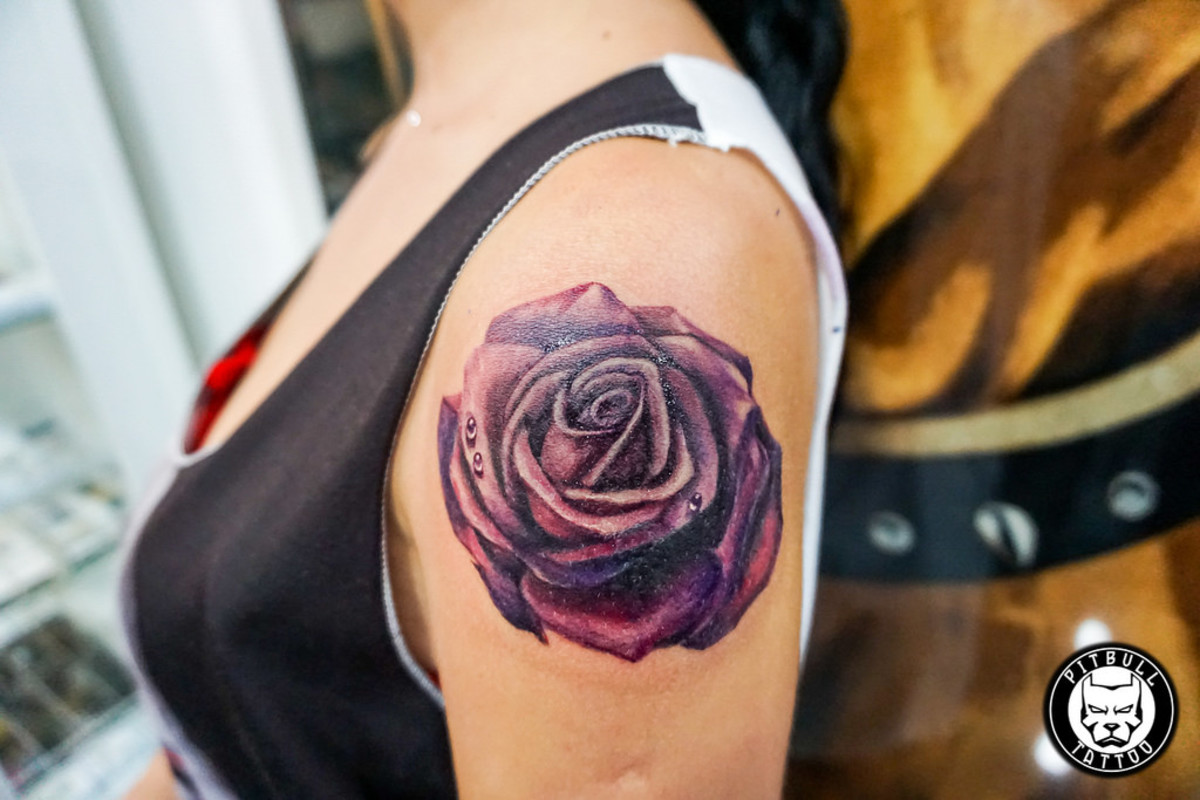 This large rose tattoo is a bold purple design.