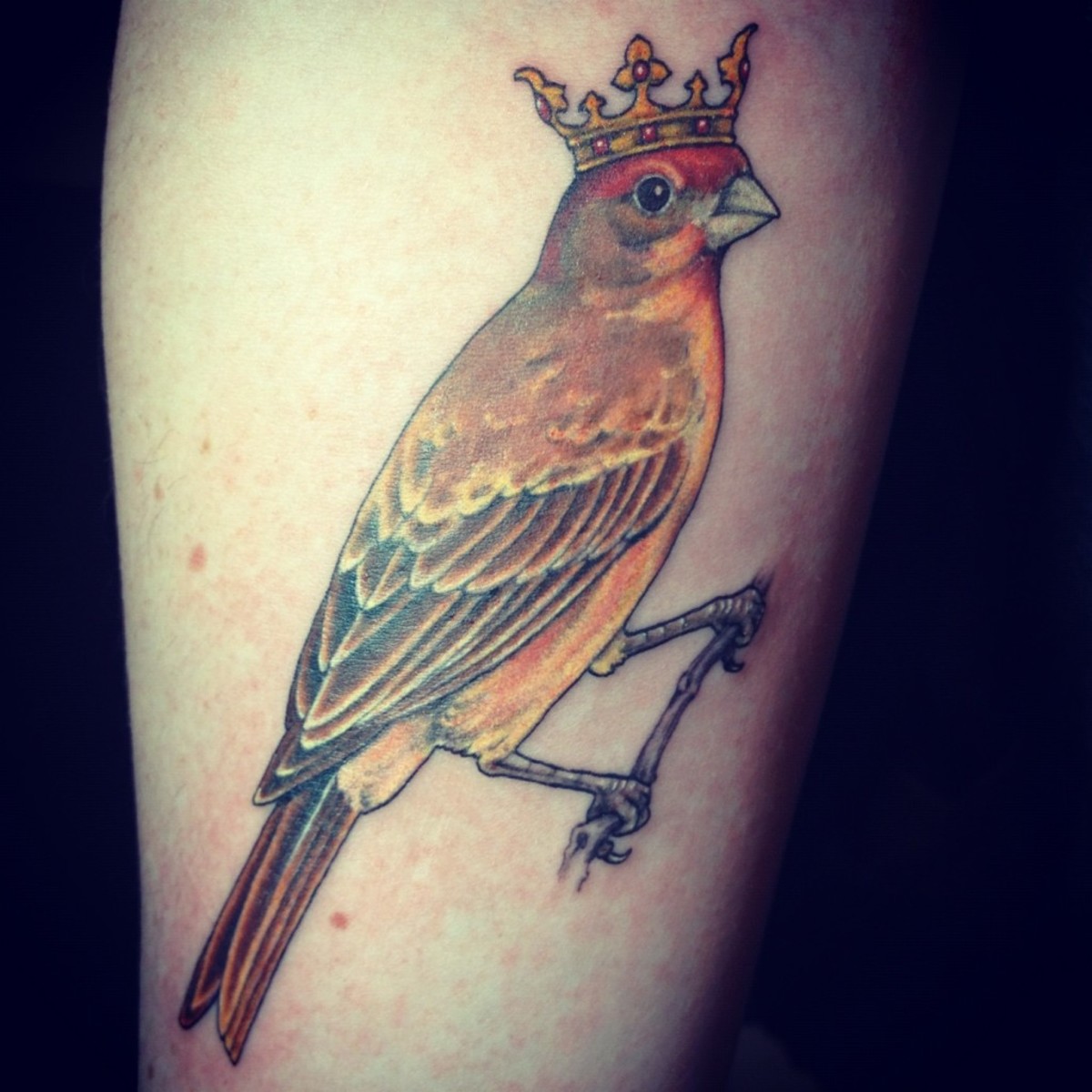 A tattoo of a yellow bird with a crown.