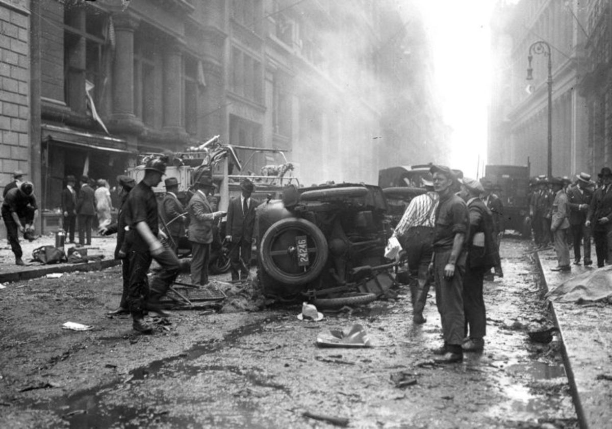 Firefighters, police, and civilians view damage in the aftermath of the Wall Street Bombing of 1920.