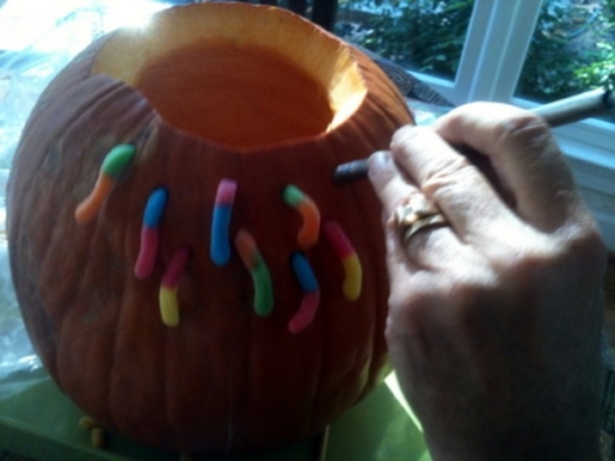 Carving holes for the gummy worms in the pumpkin