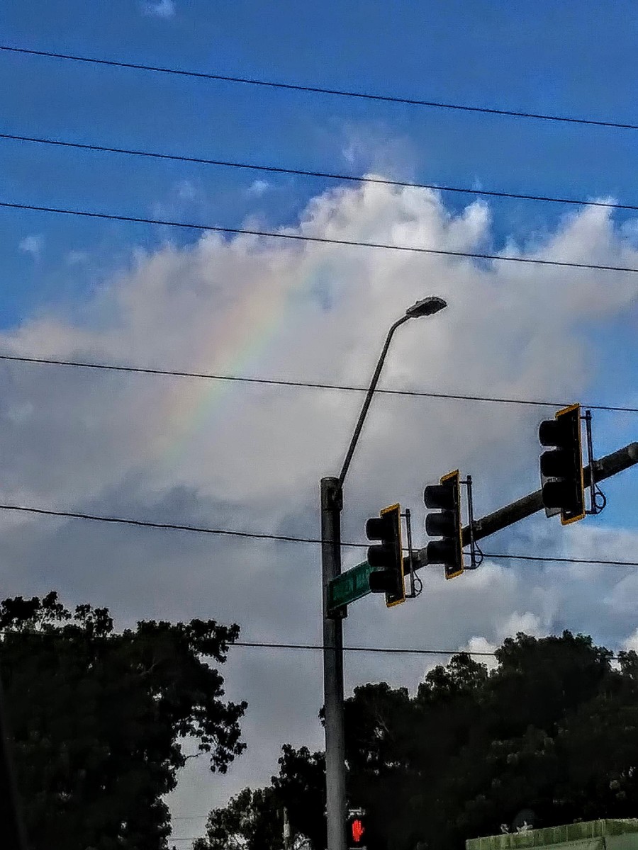 May 2, 2021@3:51pm. Sunny Isle lights, taken the right turn back road hess, going east St. Croix, to the business office, it was so much traffic but I looked up and there it was, Smiles snap a rainbow.