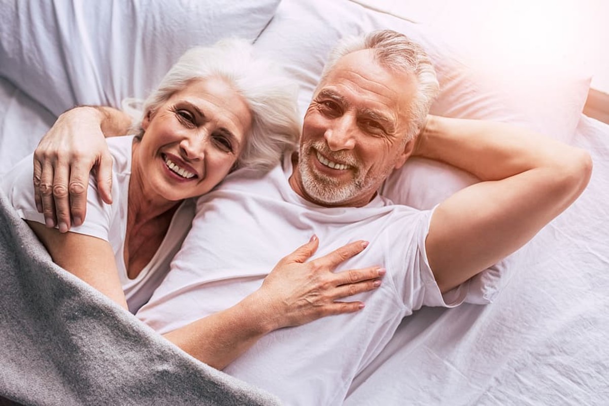 Living the Dream:  Happy senior couple in bed together.