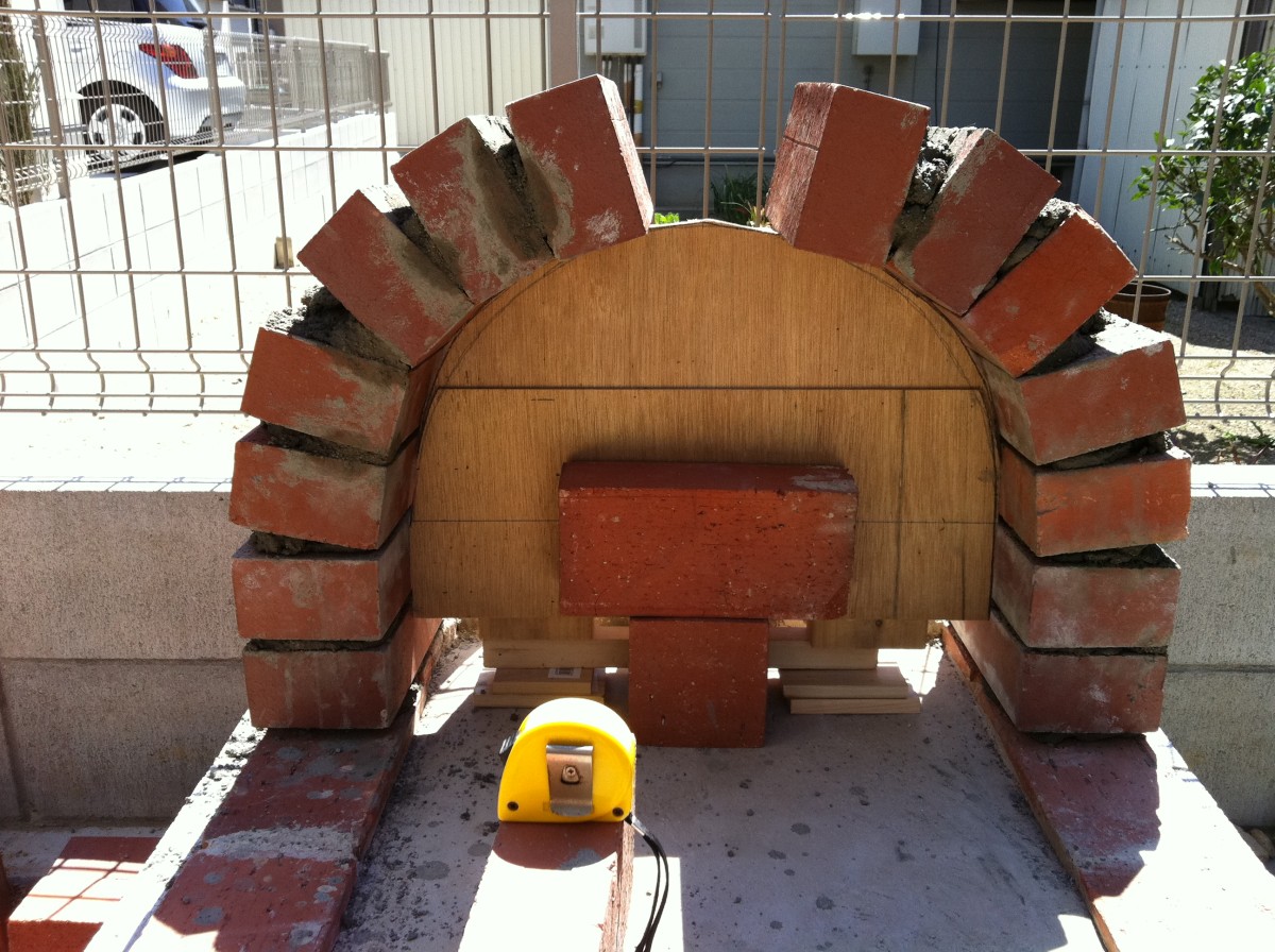 The base has a red brick arch. It stands up by itself..... Amazing!