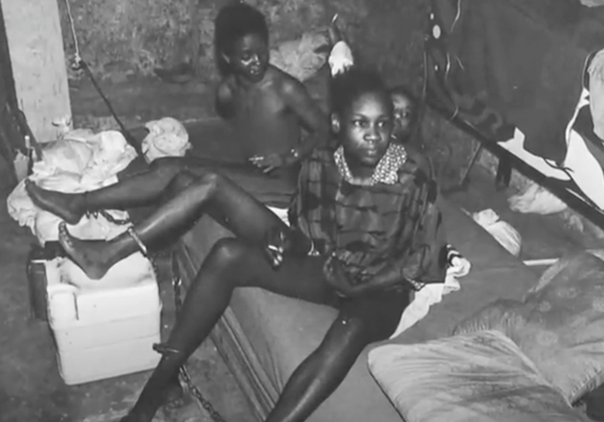 Lisa Thomas (front), shackled on the bed in the cellar of Gary Heidnik’s home. Photo courtesy of Daily Mail.
