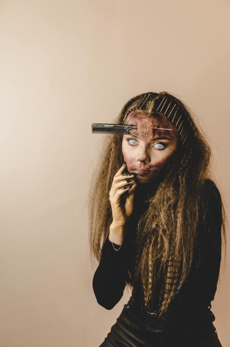 A girl wearing a comb stabbed through her forehead. 
