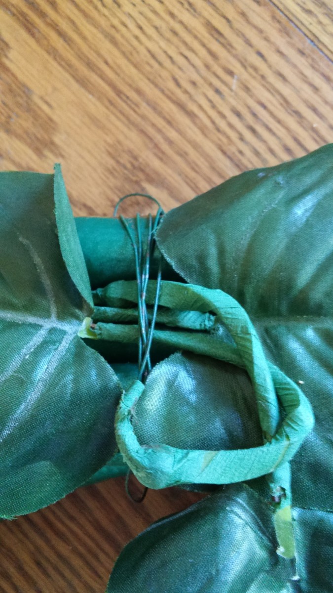 Since the essence of my design is simple, I wanted my flowers to be held by one wire wrapping as shown.  I chose to wrap only the base leaves for now.  Leaving wire on spool, wrap many times, then cut and tuck end under wrapped wire.
