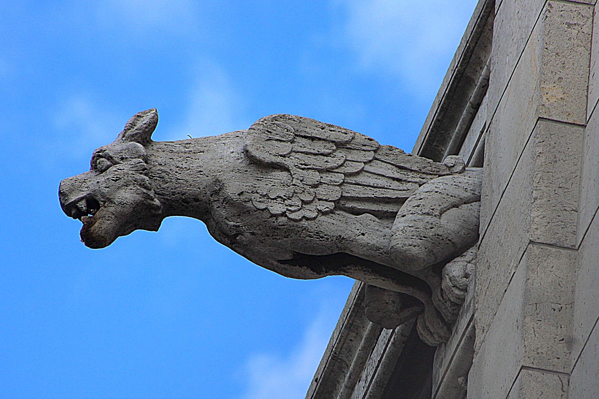 A gargoyle at Sacre-Coure. When taking a photo like this, usually it is best to take up a position which ensures the sky is behind the gargoyle to avoid the subject matter being lost against the stonework of the building