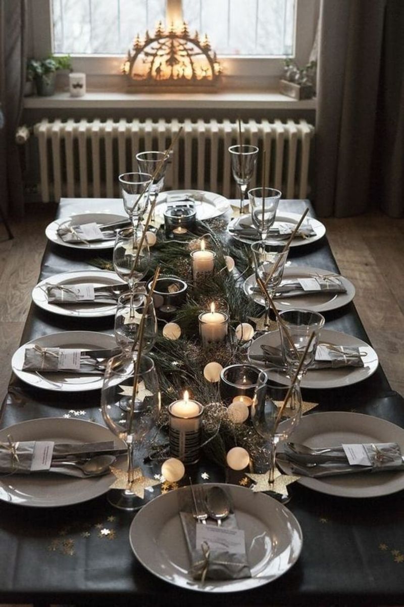 The silvery evergreen boughs in this centerpiece pair beautifully with the candles and white baubles.