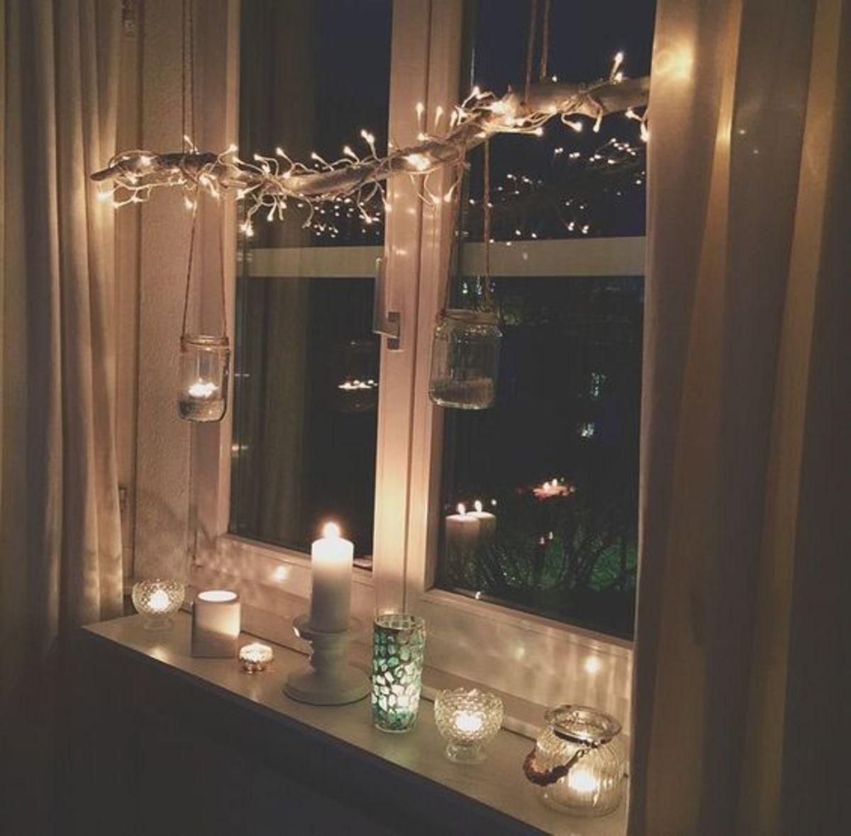 I love the simplicity of this window: Wrap a long branch with white lights, hang it in the window, and place white candles below.
