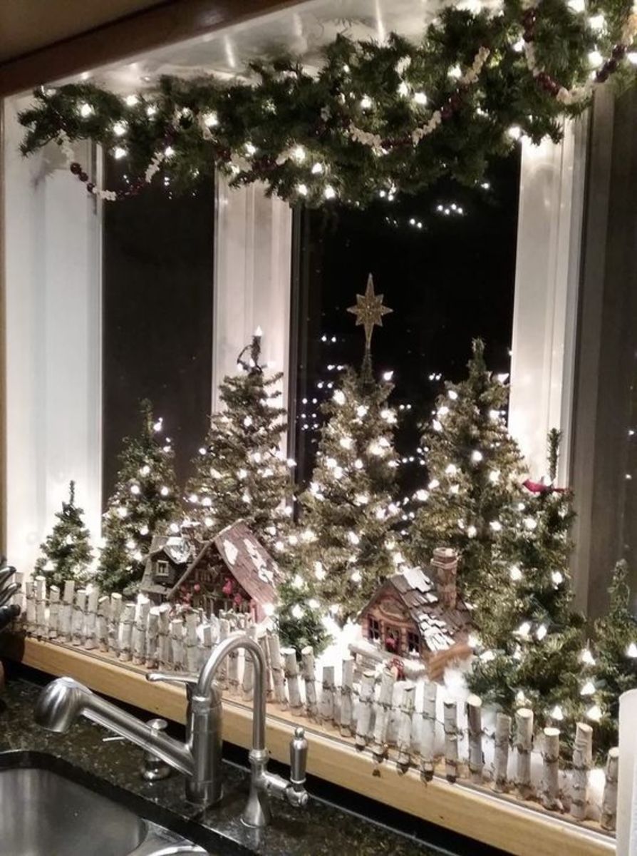 This display uses an evergreen swag at the top and mini faux Christmas trees below—not to mention tons of white lights!