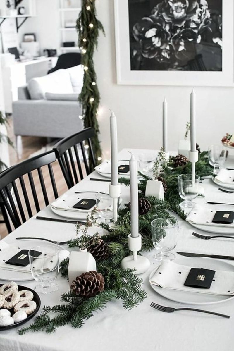The stately candlesticks take center stage on this table, backed by a simple display of greenery and pinecones.