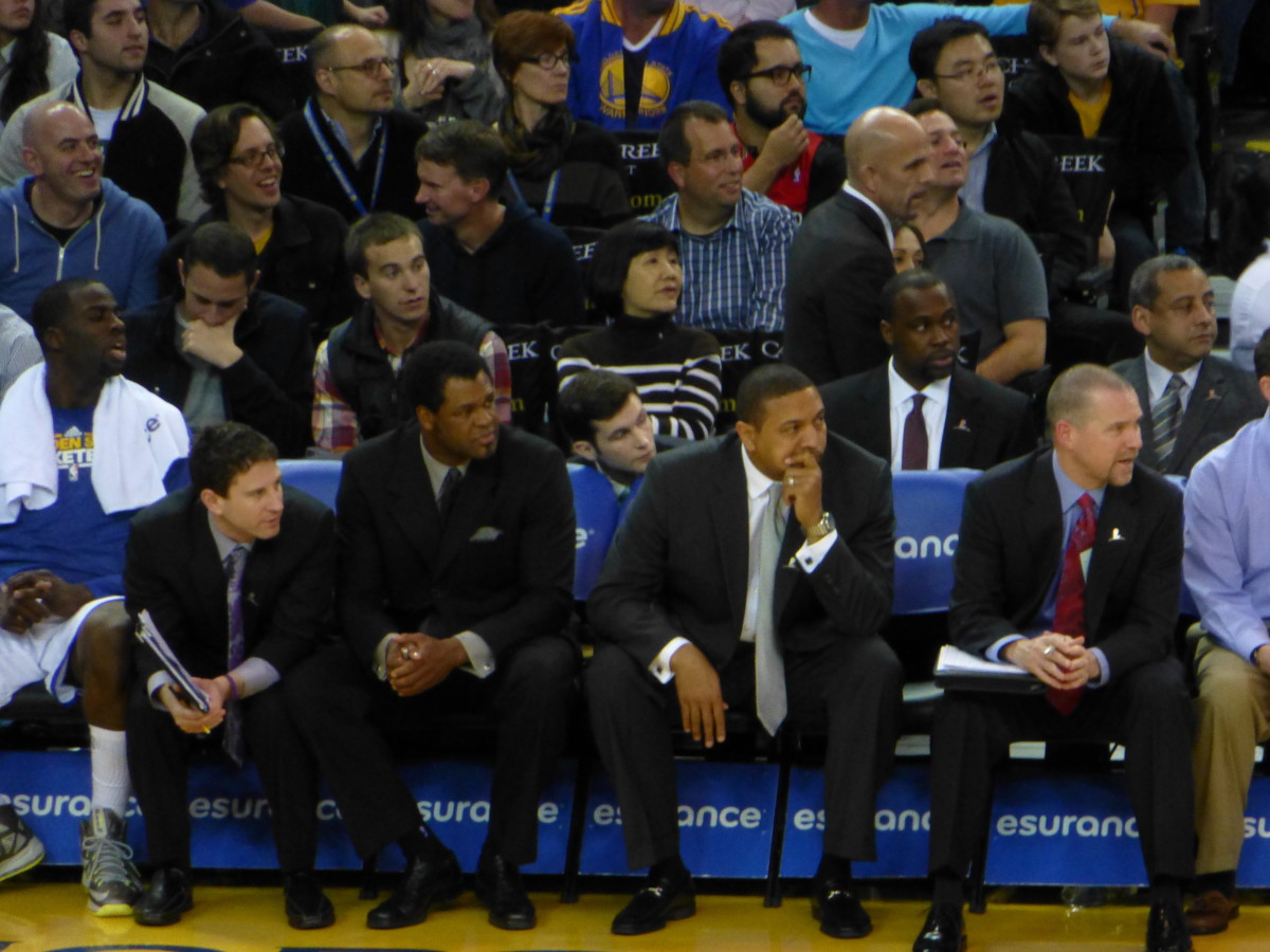Mark Jackson seated among Golden State Warriors assistant coaches during his stint as the team's head coach.