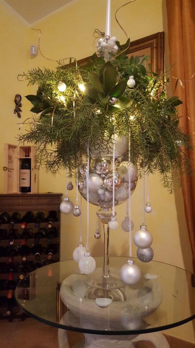 Fill a large glass vase with silver baubles and Christmas greens.