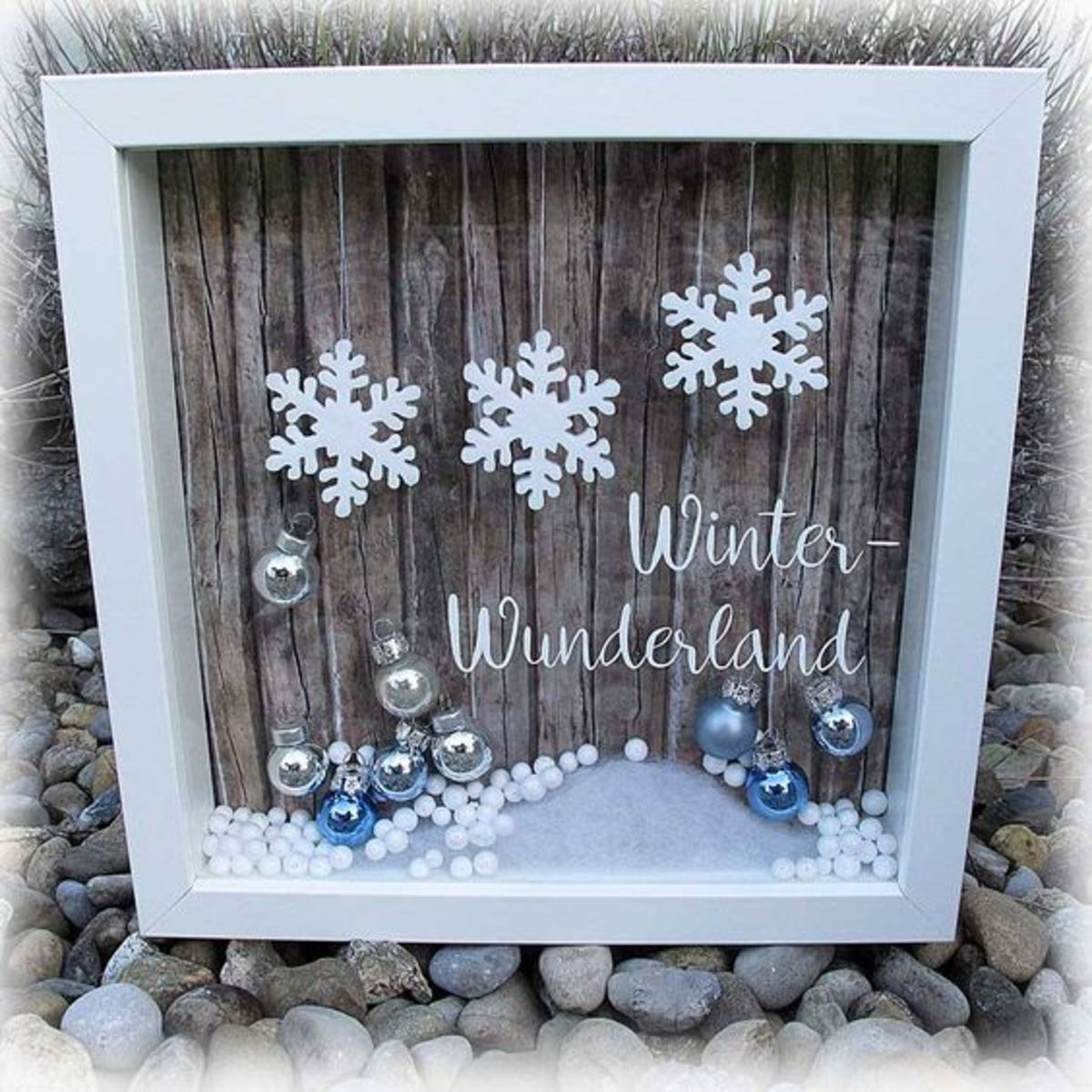 This shadow box uses rustic wood and white snowflakes.