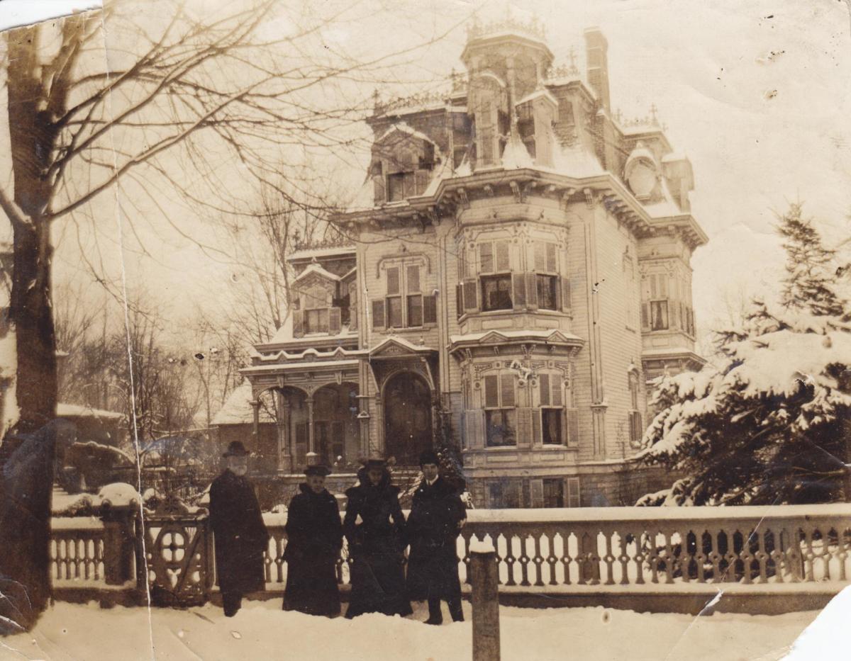 Photograph of Mackenzie Bowell, two women and a man standing outside C. P. Holton's house on Charles Street in Belleville, Ontario in winter.
