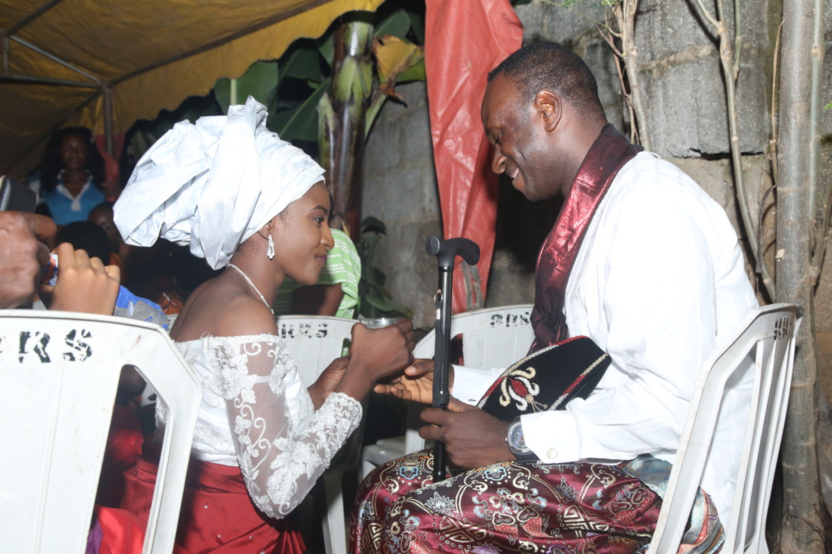 This is a photo depicting the bride gives the groom palmwine.