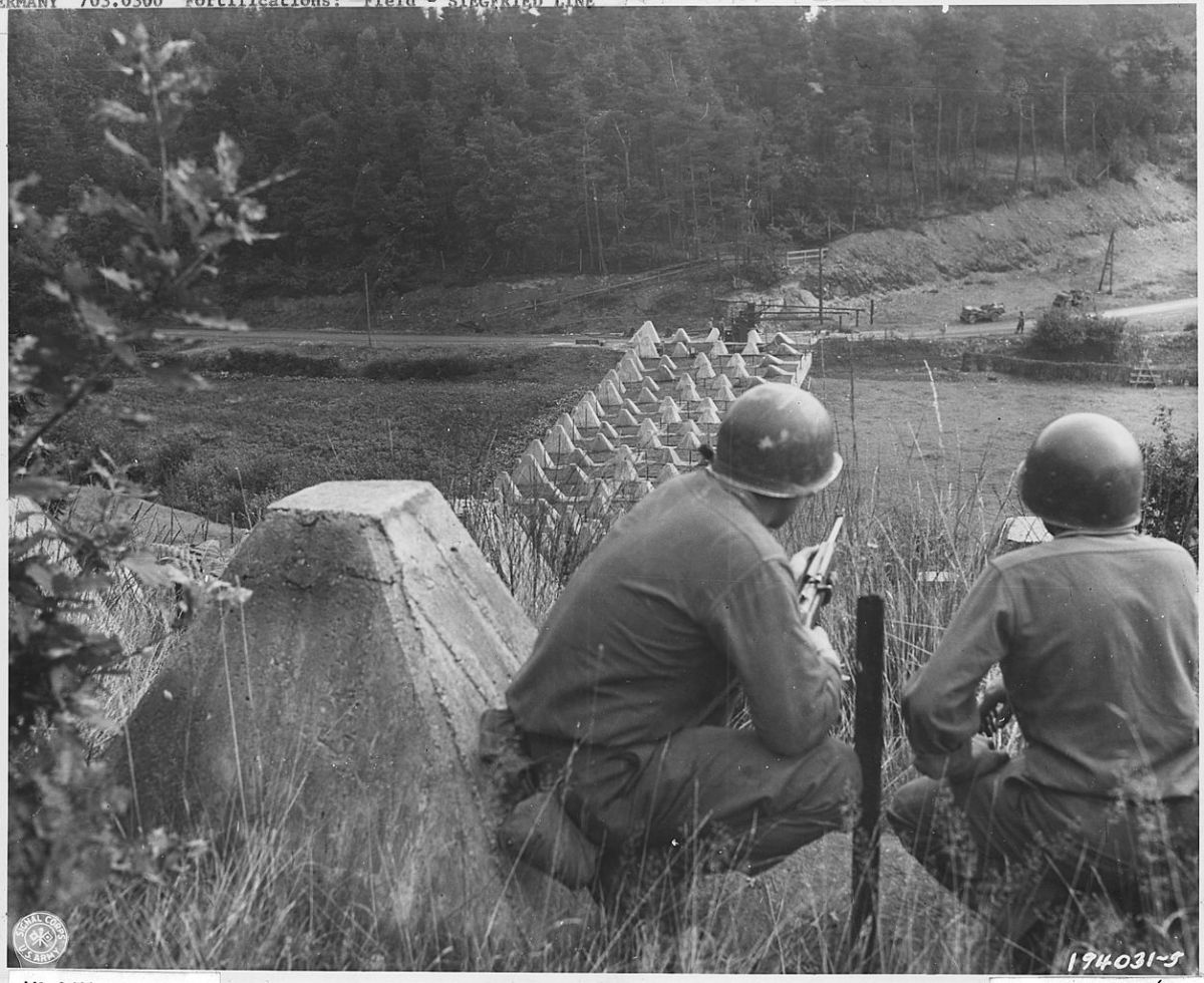 American soldiers pose near concrete 'Dragons Teeth' at the West Wall (aka Siegfried Line) in Germany.