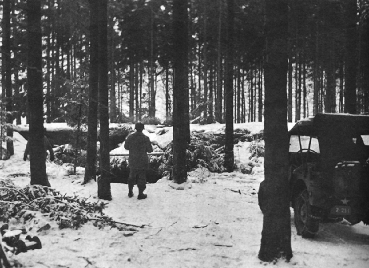 American G.I. standing in front of a captured German pillbox complex in the Hurtgen Forest.