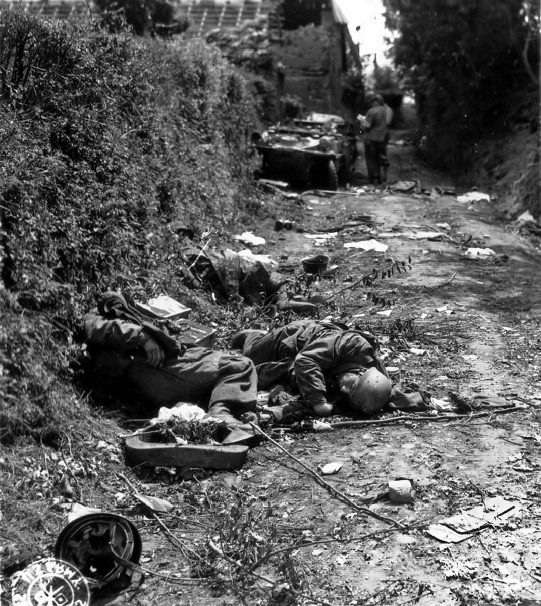 Dead German soldiers on a rural road.
