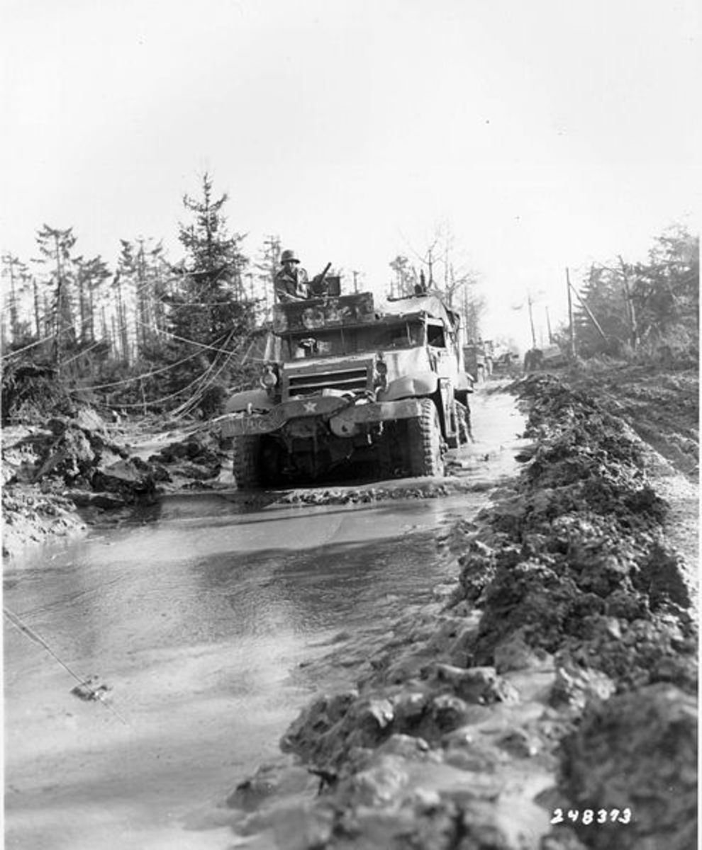 Typical muddy road in the Hurtgen Forest. American halftrack in the foreground.