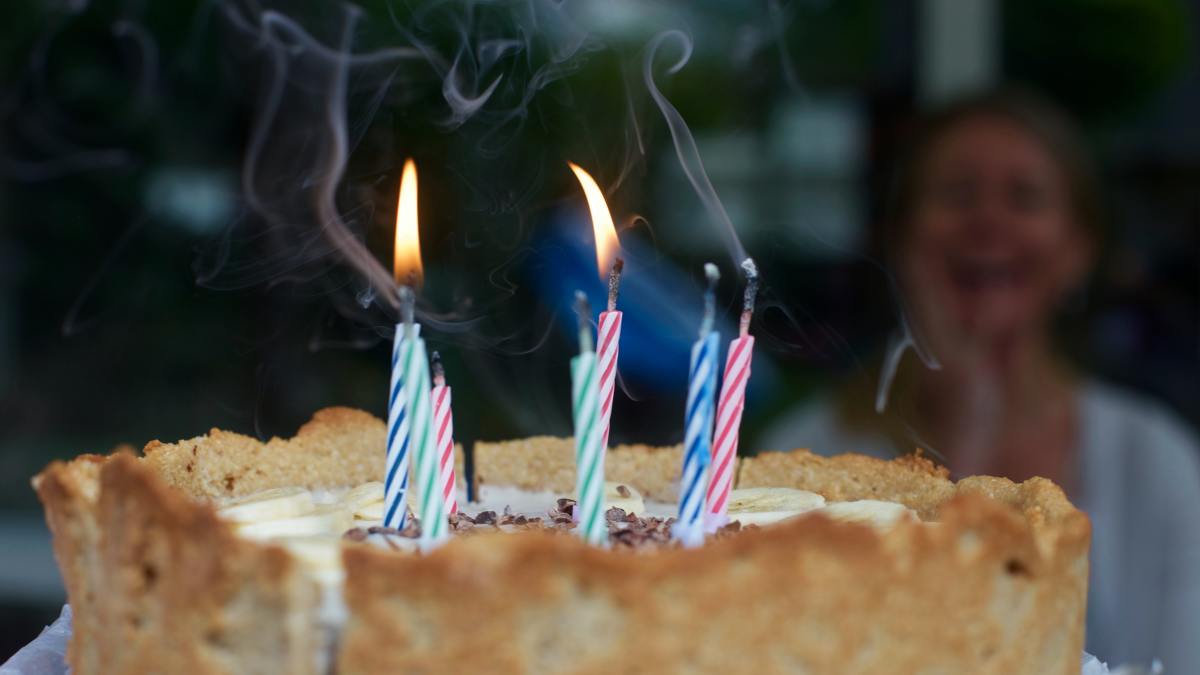 Bring out a cake with candles that focuses on the person celebrating his birthday. Photo by Matthias Zomer from Pexels