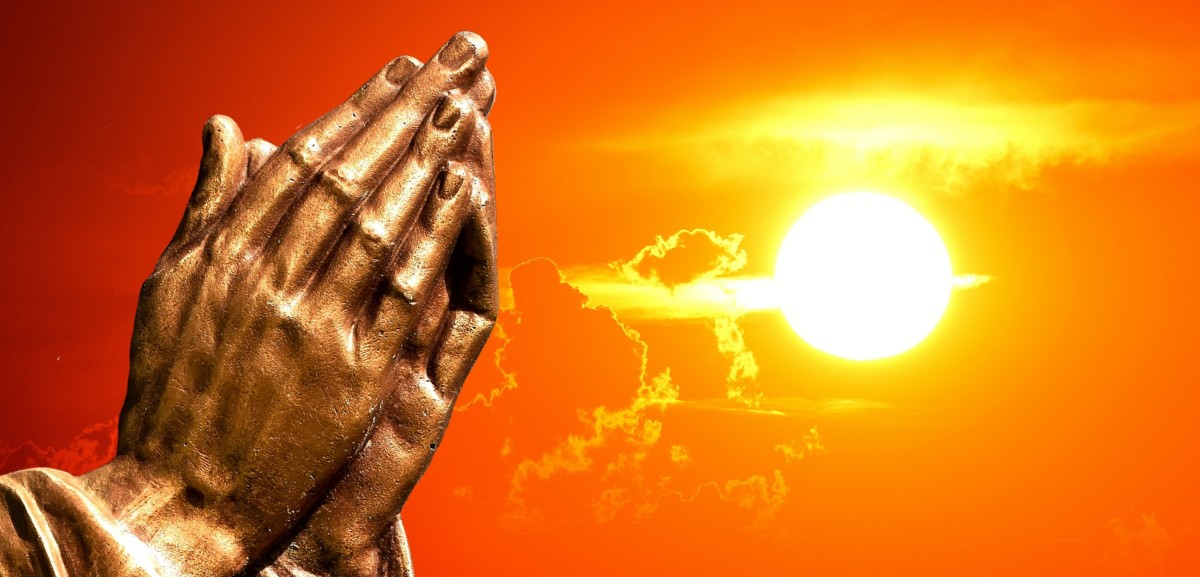 Hands clasped in prayer in the daylight hours