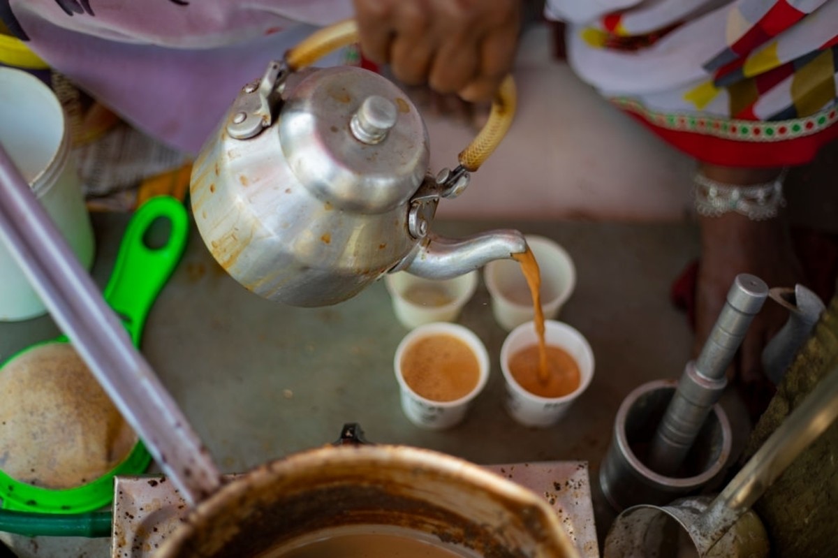 Tea is served in the cup through a kettle in rural India. 