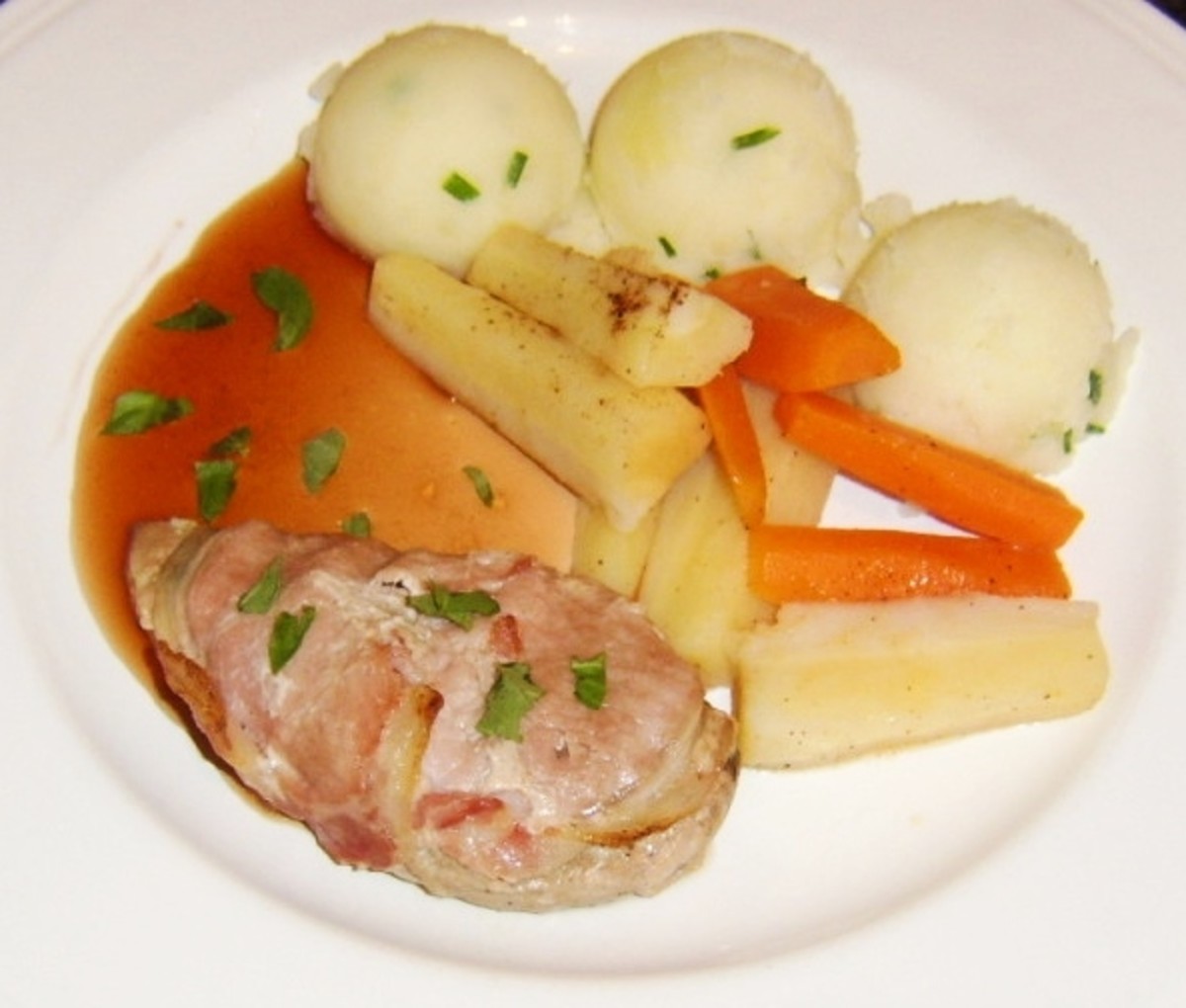 Pheasant breast is cooked wrapped in bacon and served with vegetables and a redcurrant and cider sauce