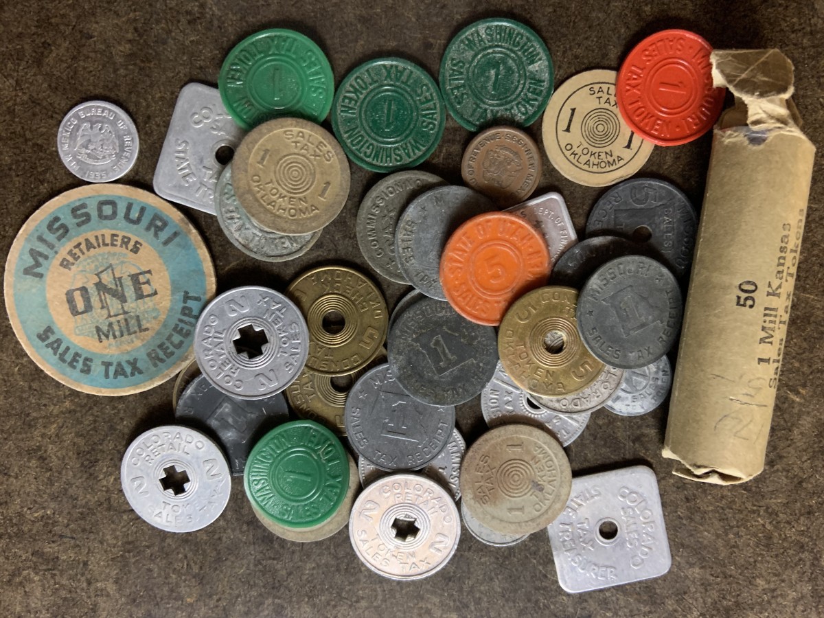 A collection of sales tax tokens for various states.