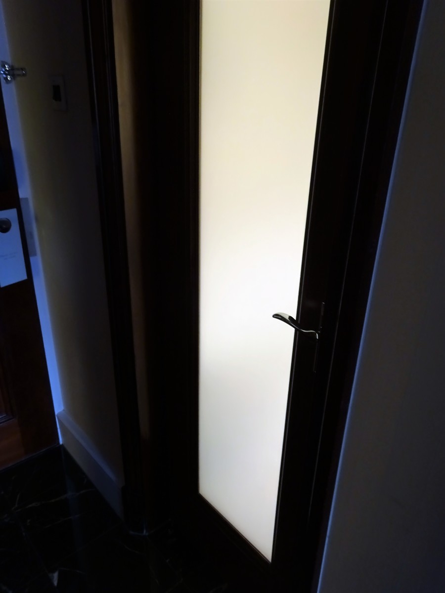 Light streams into the bedroom from the bathroom door.