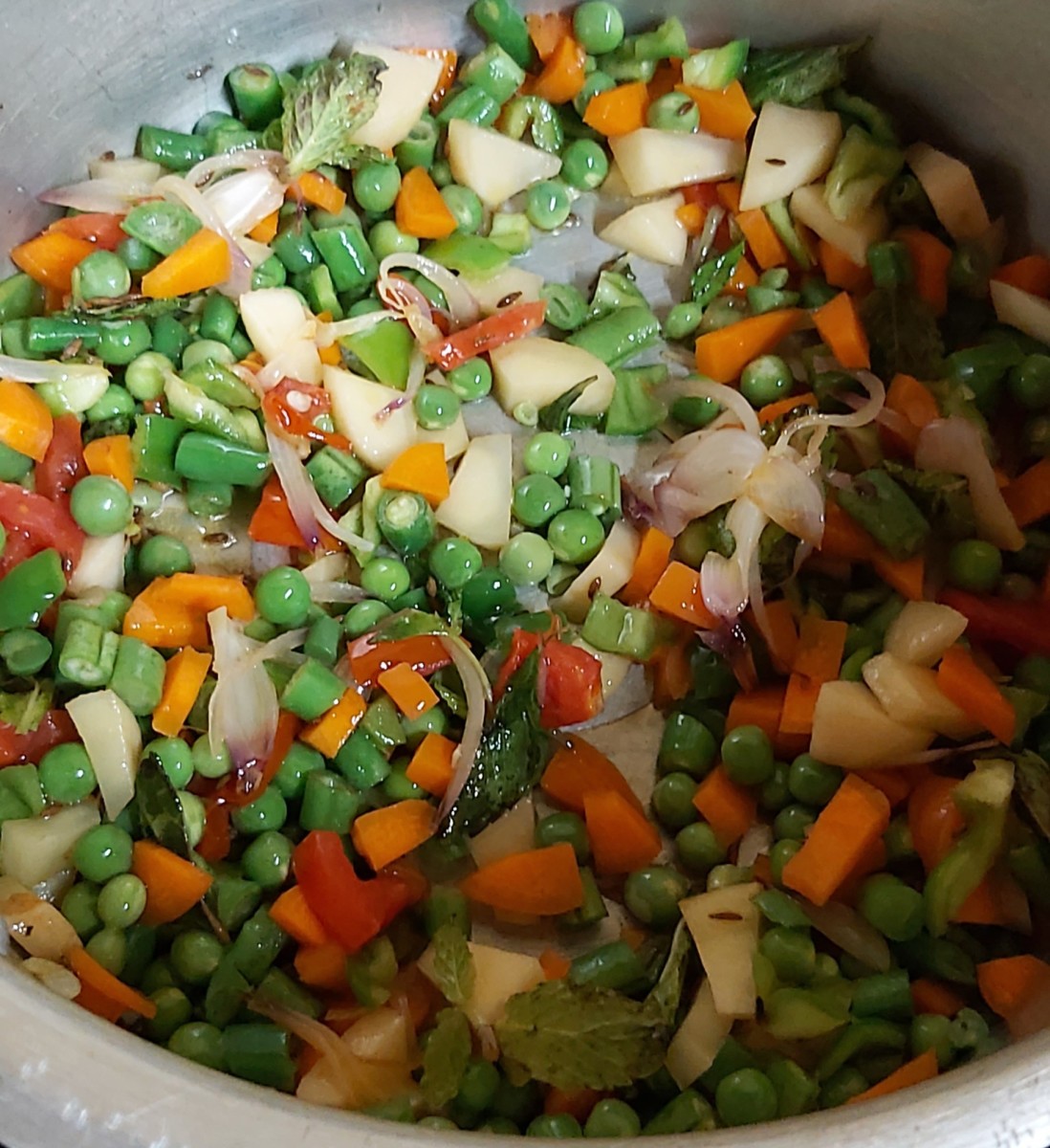 Add all chopped vegetables, peas and mint leaves. Fry for 2 minutes.