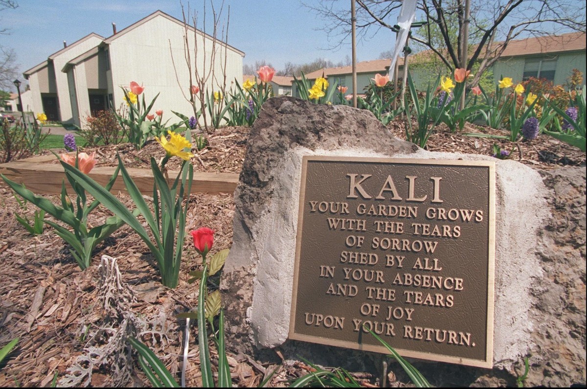 Kali Poulton’s flower garden outside of Gleason Estates where people still visit, leaving balloons, stuffed animals, and other mementos. Photo courtesy of the Democrat Chronicle.