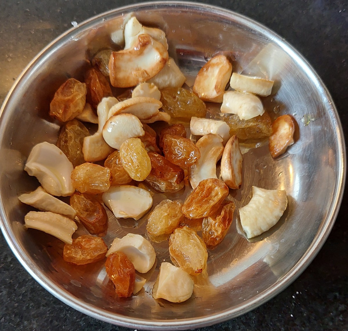 Fry till cashews turn golden and raisins puff up. Remove from pan and set aside.