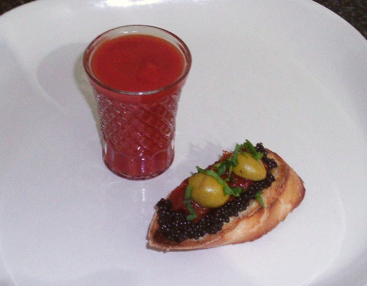 Caviar on bruschetta with olive and sun dried tomato, served with a Bloody Mary shot