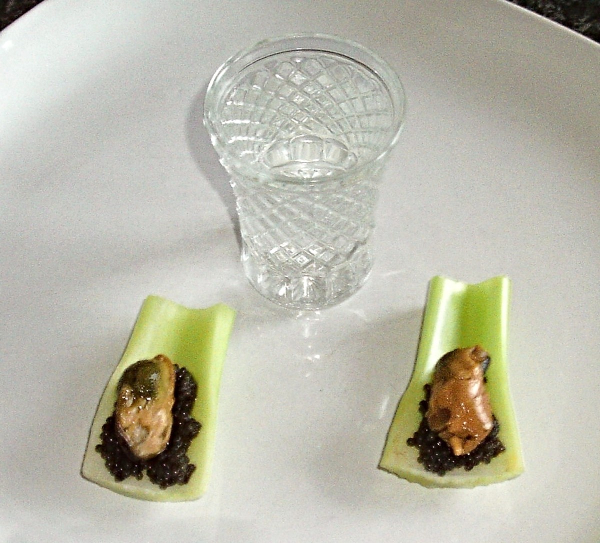Smoked mussels and caviar are served on celery spoons with vodka shot
