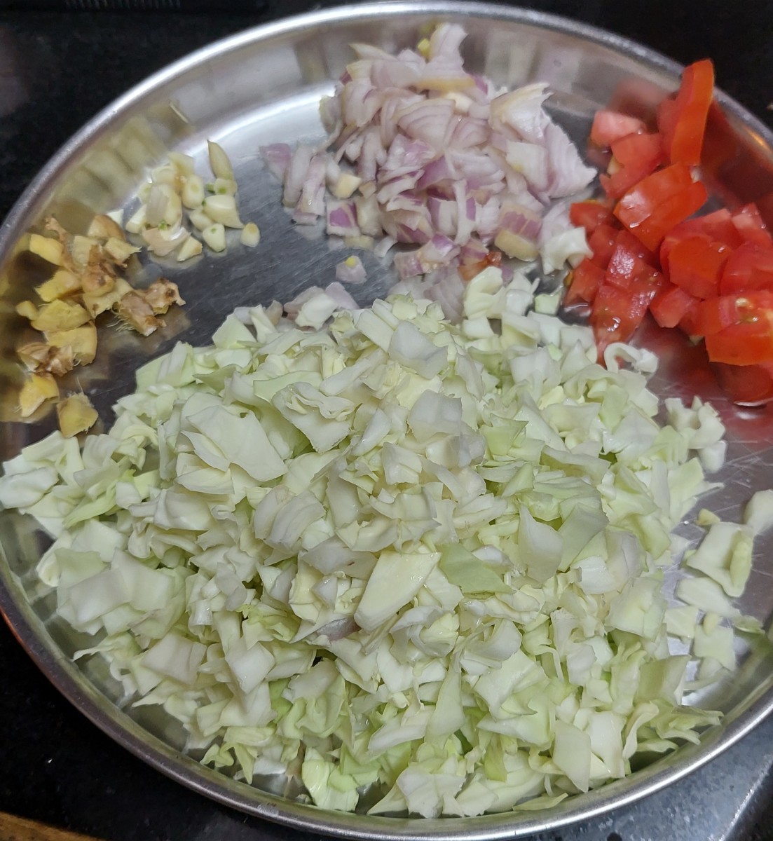 Finely chop cabbage (discard the stalk), onion, tomato, fresh ginger, garlic and green chilies. Set aside.
