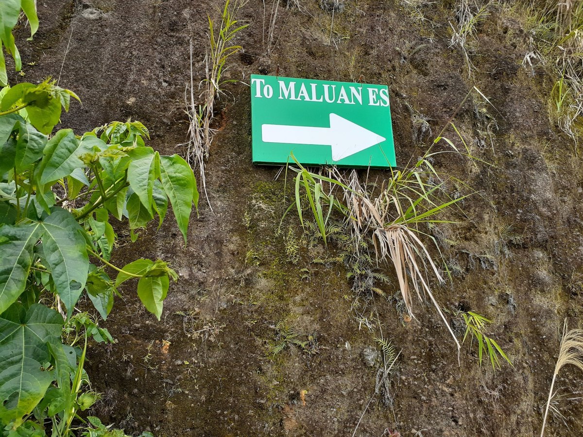 When you notice this arrow direction sign, pull over to the side of the road and begin walking through the first fall of Maluan Es Falls.