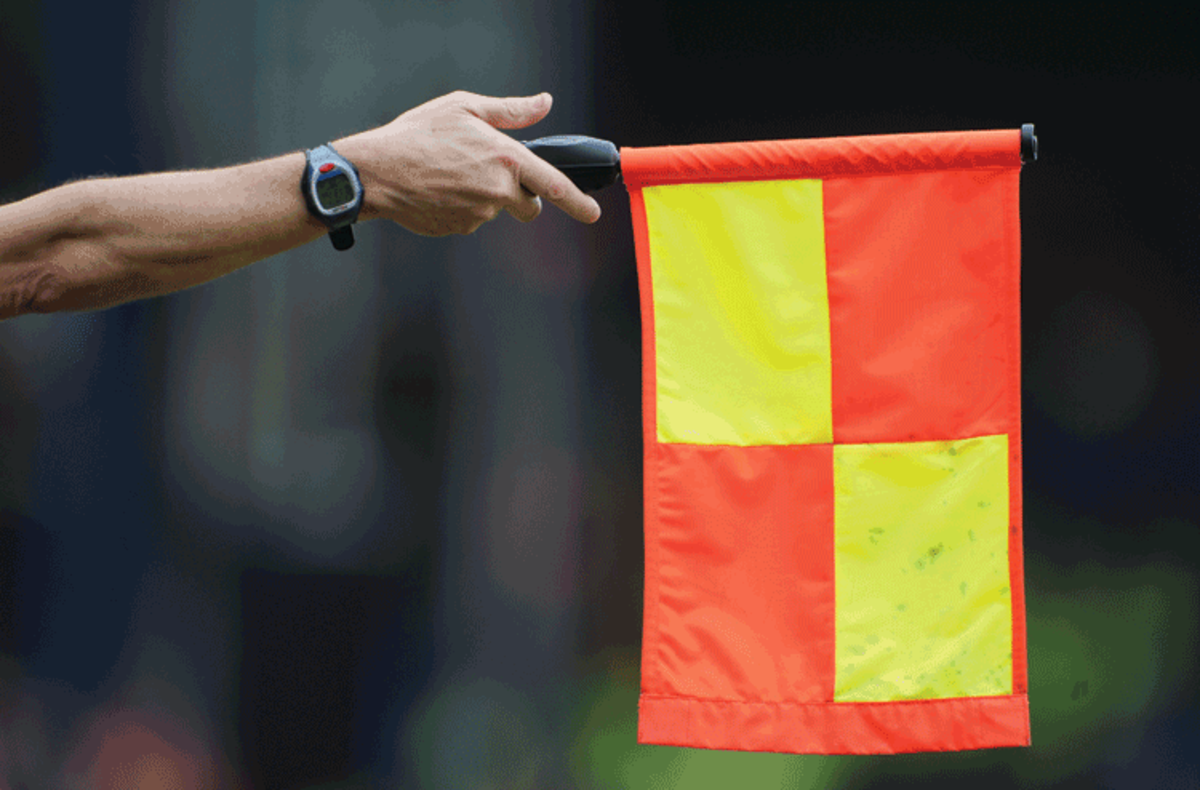Linesman waving the offside flag sign during a match. 