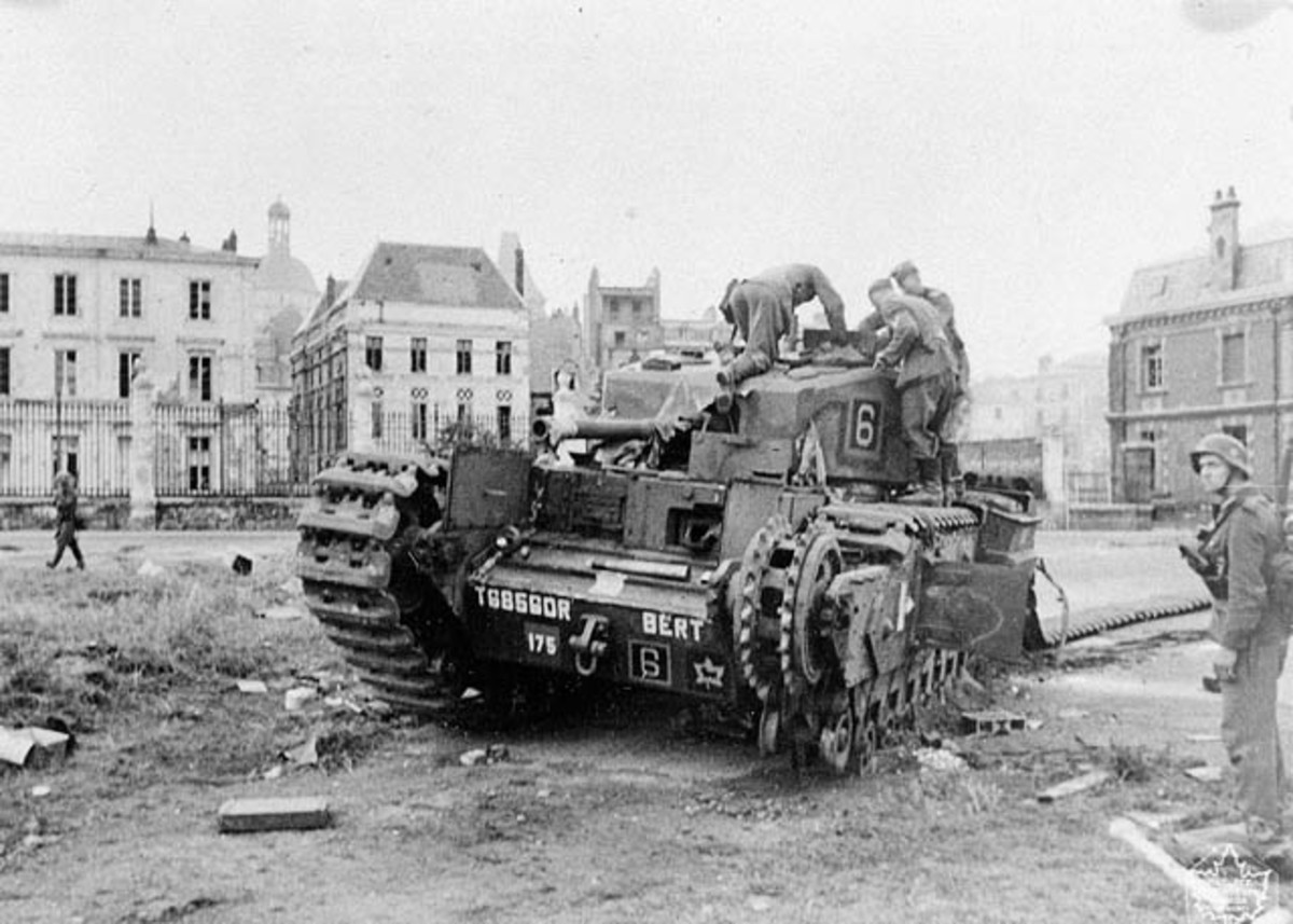 German soldiers look over a wrecked Churchill tank - note Canadian emblem on right lower body